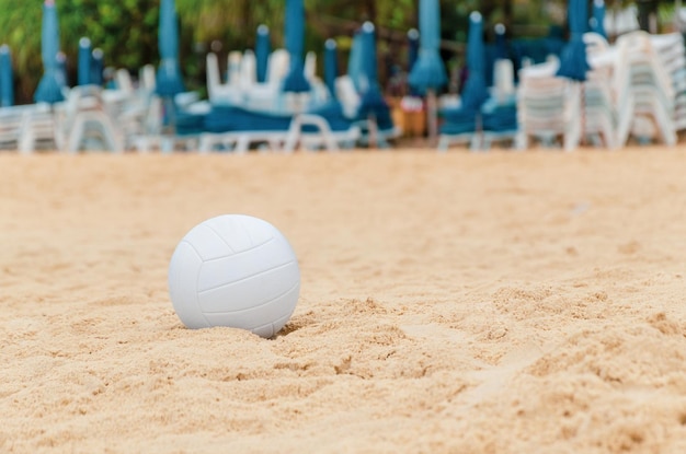 Witte volleybalbal op zand op het strand Uitrusting voor actieve strandrecreatie buitensporten