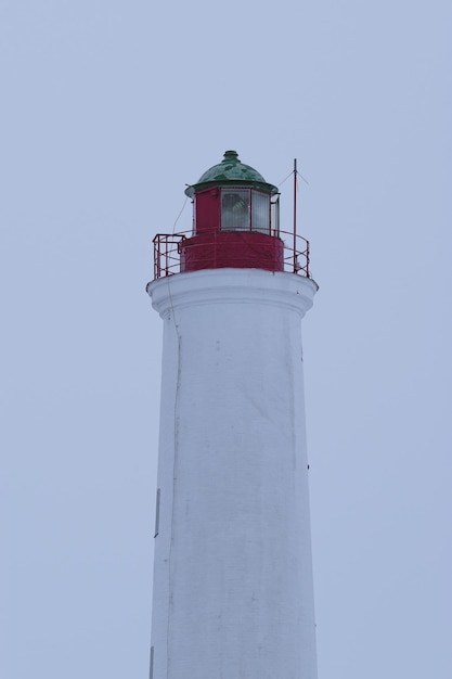 witte vuurtoren met een rode top en een groen dak