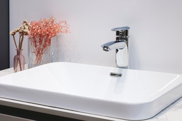 Foto witte wastafel met kraan op houten aanrecht in minimalistisch modern badkamer scandinavisch interieur met stijlvolle grijze muur en ronde spiegel kopieerruimte en niemand