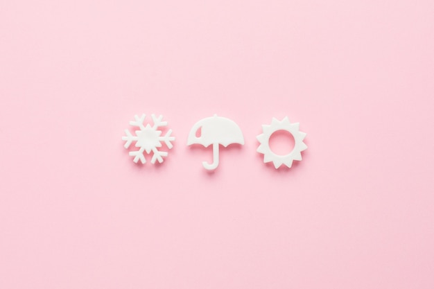 Foto witte weerelementen in een minimale stijl op roze, bovenaanzicht.