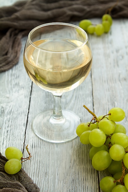 Witte wijn in een glas met een tros groene druiven