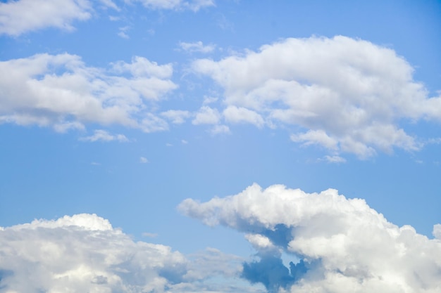 Witte wolken als achtergrond tegen een lichtblauwe lucht verzamelen zich in gezwollen wolken