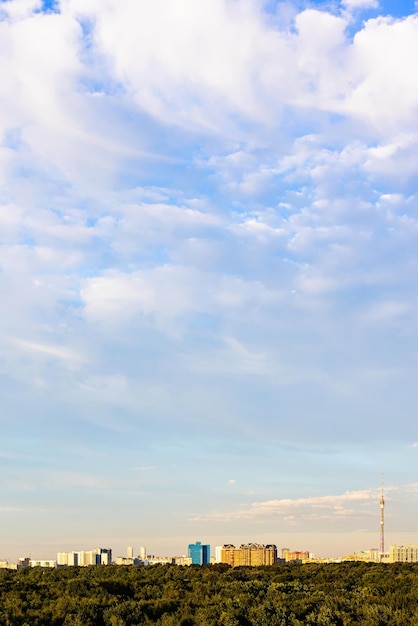 Witte wolken in blauwe lucht boven stadspark bij zonsondergang