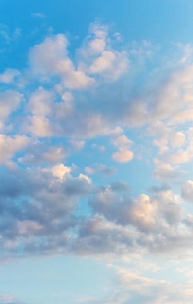 Witte wolken in de blauwe lucht verlicht door de avondzon