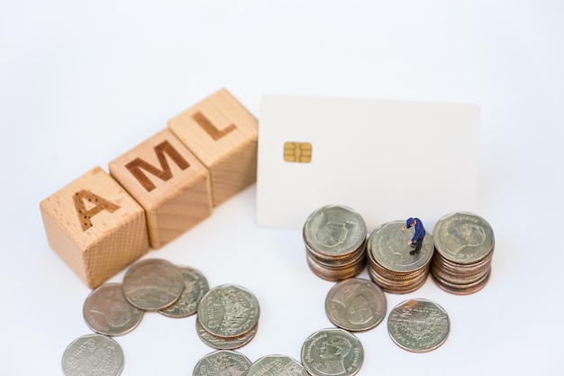 Foto witwassen van geld concept. miniatuurmensen, officier die stapel munten onderzoekt en houten woordblok