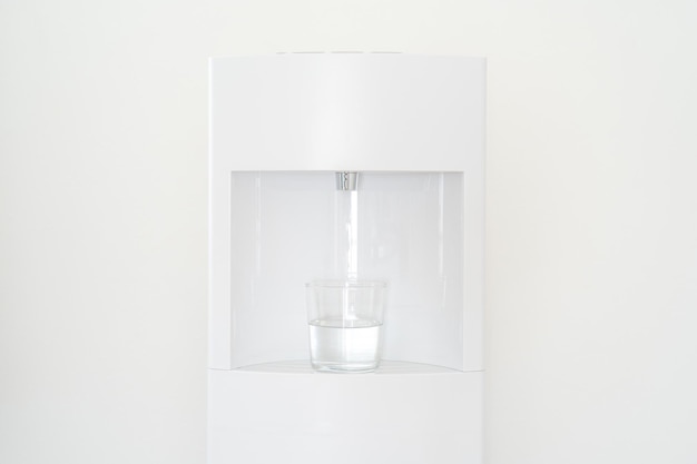 Foto witwaterdispenser en een glas in de kamer