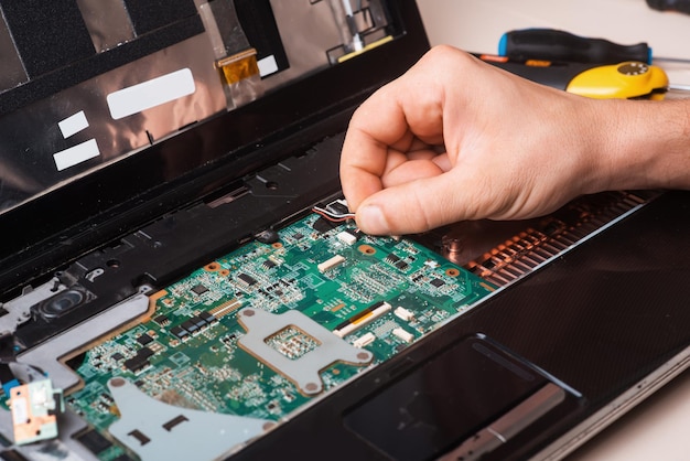 Wizard repairs laptop with tools and hands