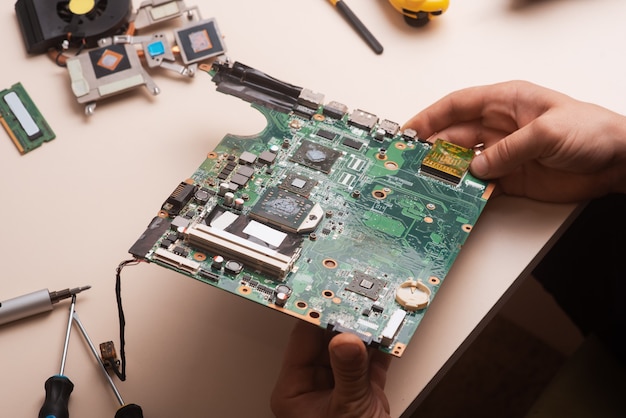 Wizard repareert laptop met gereedschap en handen