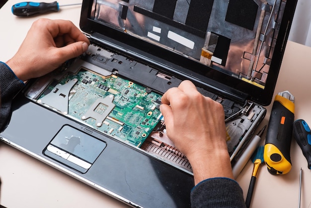 Wizard repareert laptop met gereedschap en handen