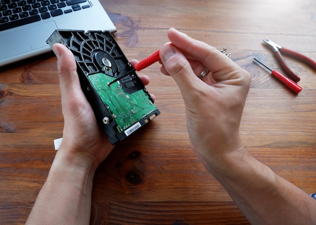 The wizard restores and cleans the hard drive Firstperson photo Hands with a tool closeup