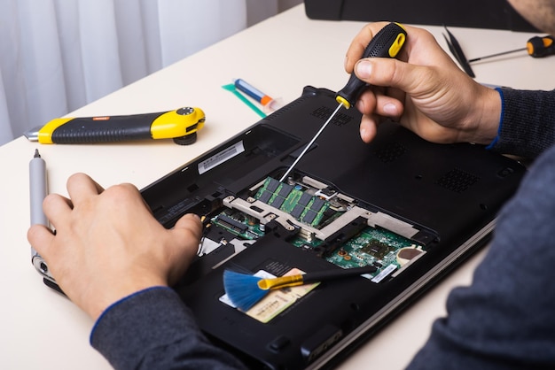 The wizard restores the laptop Disassembly of the laptop into spare parts Board part of laptop for recovery Maintenance of computer equipment using tools View of the laptop inside