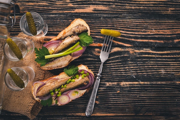 Wodka en een set sandwiches met sprot en kaviaarui en peterselie op een houten ondergrond Bovenaanzicht Kopieer de ruimte