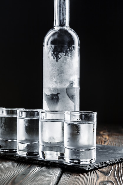 Wodka in geschotene glazen op rustieke houten achtergrond