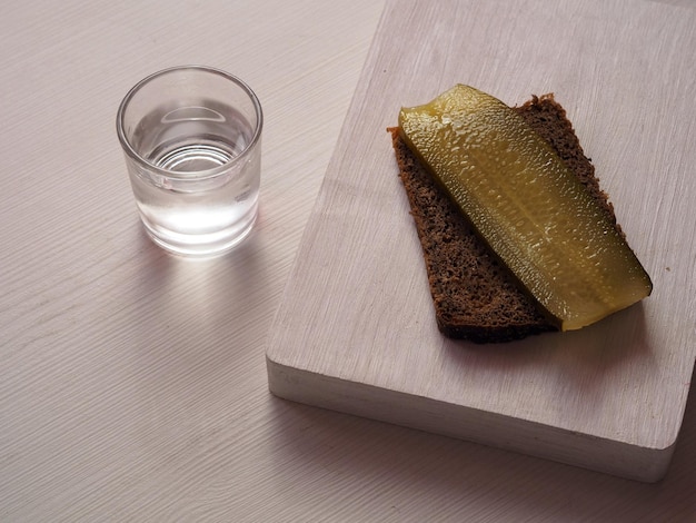 Wodka in glas en voorgerecht op witte tafel