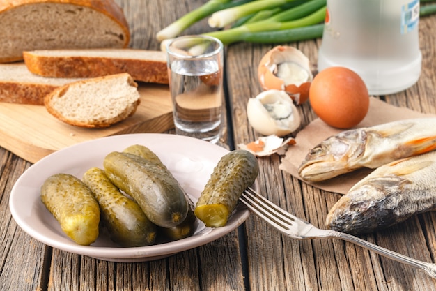 Wodka met traditionele Slavische snacks op tafel - haring, gepekelde komkommer, ei en ui