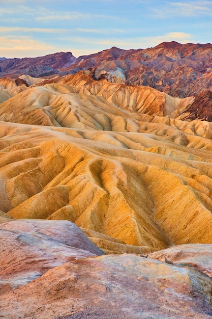 Woestijnbergen met kleurrijke sedimentgolven tijdens zonsopgang
