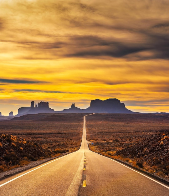 Woestijnweg die bij zonsondergang naar Monument Valley leidt