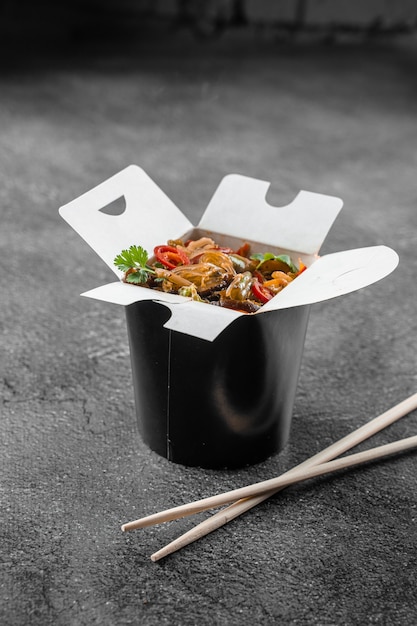 Wok in doos rijstnoedels in zwarte voedselcontainer