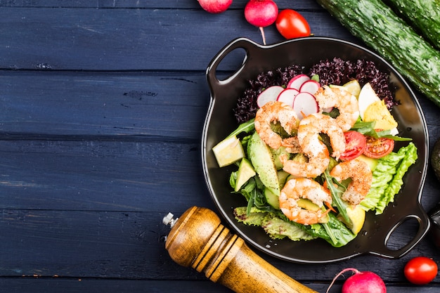 a wok of shrimp salad with vegetables