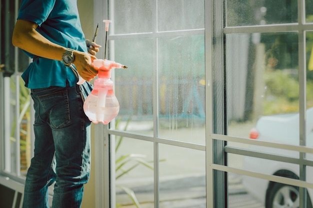 Involucro di woker che oscura una finestra usando uno spray nebbioso