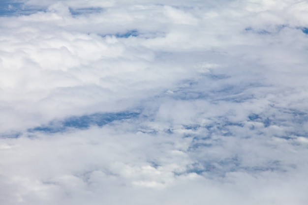 Wolken, lucht en grond, kijkend vanuit het vliegtuig.