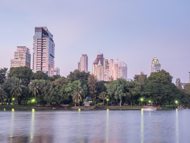 Wolkenkrabber gebouwen stadsgezicht met reflectie op meer in Lumpini park Bangkok Thailand