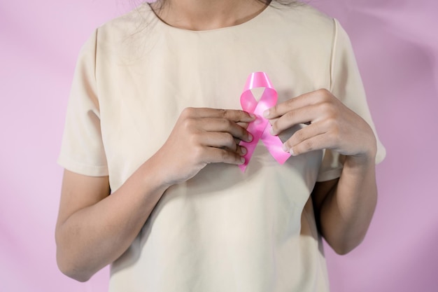Photo womaen hand holding pink ribbon breast cancer awareness concept healthcare and medicine cancer concept
