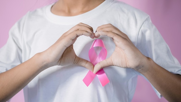 Photo womaen hand holding pink ribbon breast cancer awareness concept healthcare and medicine cancer concept