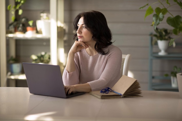 Woman 3540 years old works in a laptop at home online work