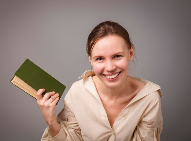 Woman 40 years old with a book on a light background