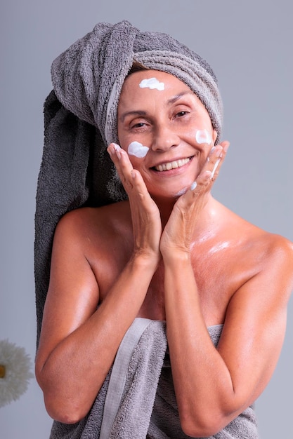 Woman over 50 with body cream treatment