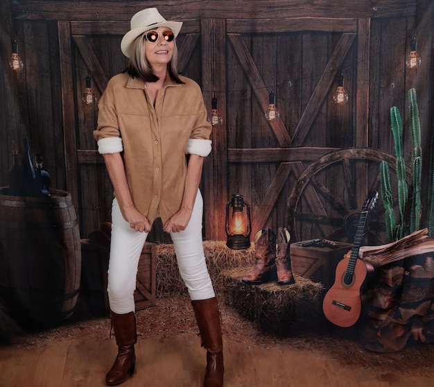 Photo woman over 60 in denim attire with a barn background