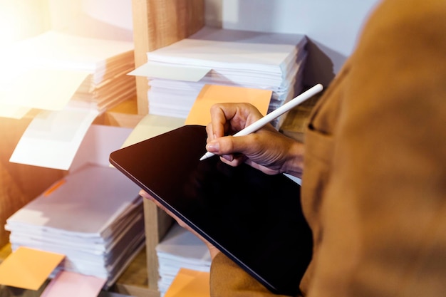 Woman accountant use calculator and computer with holding pen on