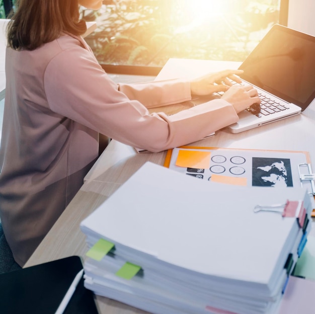 Woman accountant use calculator and computer with holding pen on