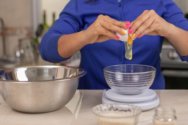 Woman adding an egg to a bowl to make bread