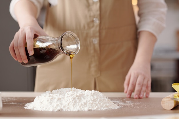 Woman Adding Golden Syrup to Flour