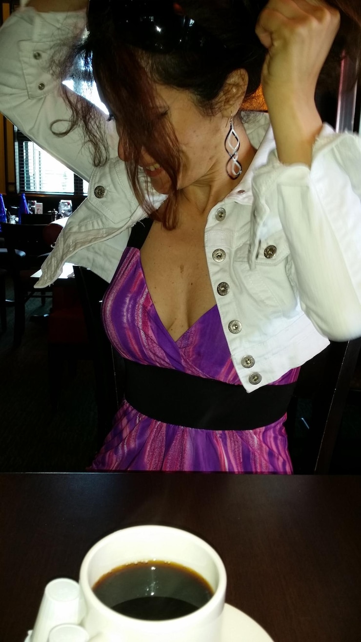 Photo woman adjusting hair at cafe