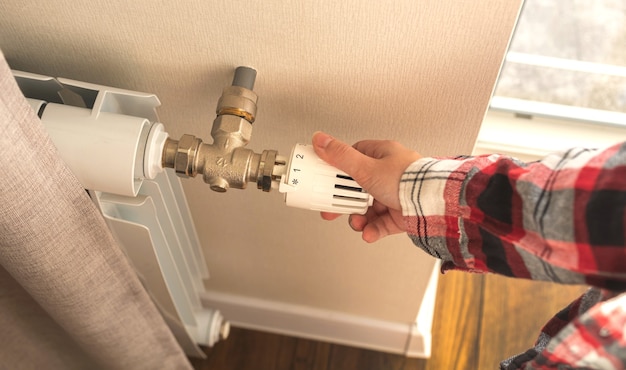 Photo woman adjusting heating radiator thermostat indoors photo