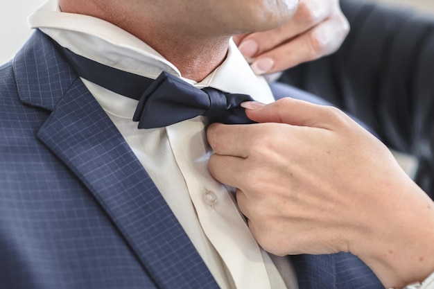 Woman adjusting man bowtie