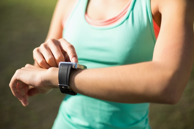 Woman adjusting a time on wristwatch