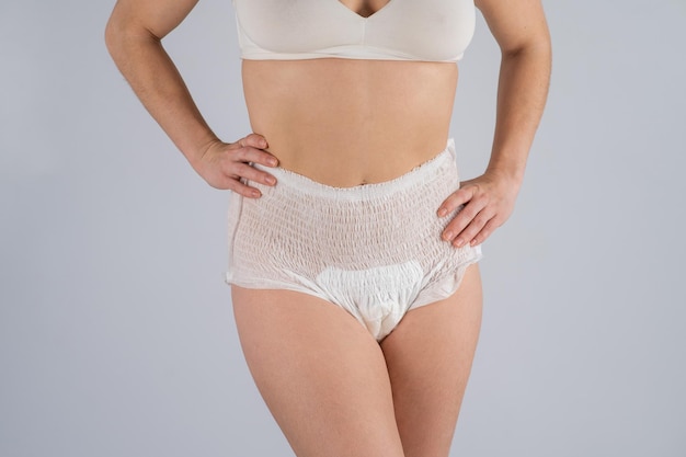 Woman in adult diapers on a white background incontinence problem