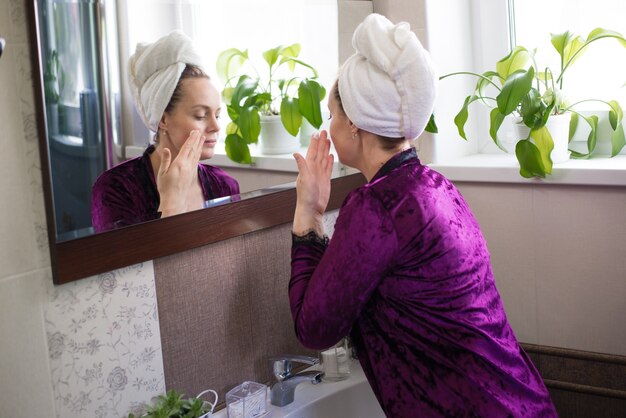 A woman after a bath does home facial skin care