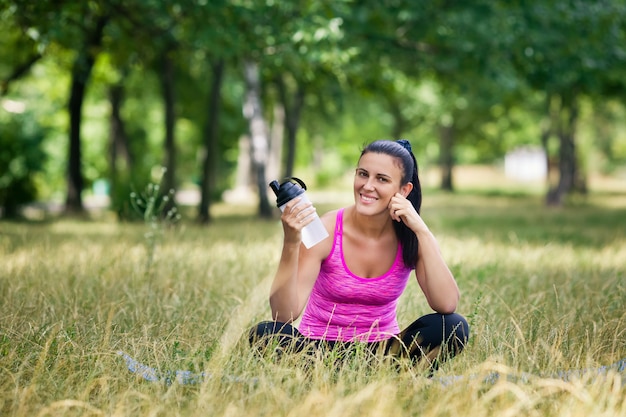 woman after yoga sitting on grass smiling