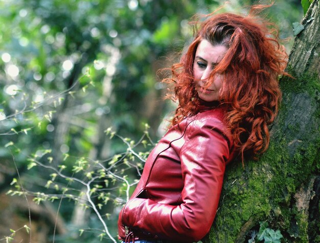 Photo woman against mossy tree trunk