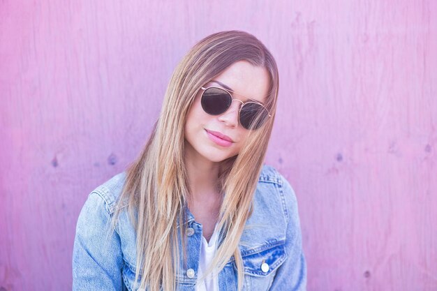 Woman against pink wooden wall