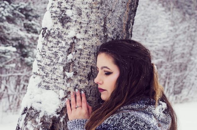 Photo woman against tree trunk during winter