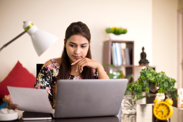 Woman analyzing documents at home