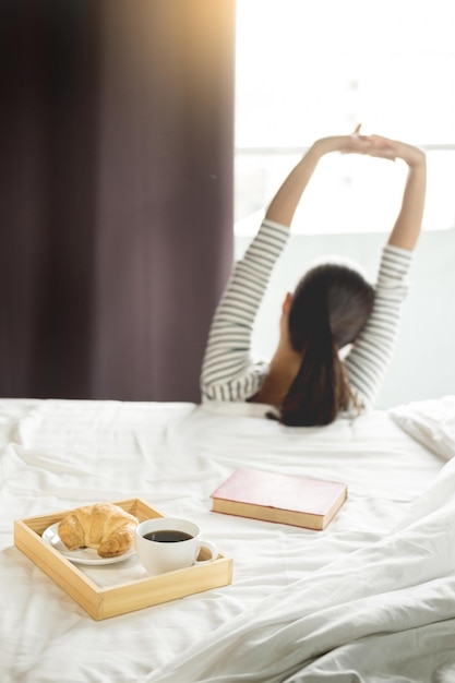 写真 女性とベッドのコーヒーカップ