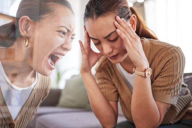 Woman anxiety and depression on sofa with headache reflection and shout with pain in home Depressed girl mental health and frustrated while angry sad and sitting on couch at house in Los Angeles