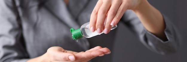 女性はウイルスの概念から手指消毒剤の手治療を適用します